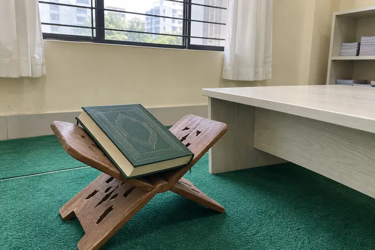 Illustrative photo: Closed Quran placed respectfully on a wooden rehal